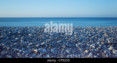 Vue sur mer ou de la plage de galets dans le bleu du crépuscule, Penmon, Anglesey, Pays de Galles, Royaume-Uni Banque D'Images