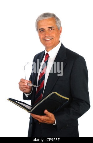Smiling middle aged businessman holding un classeur et ses lunettes alors qu'il se trouvait isolé sur blanc. Banque D'Images