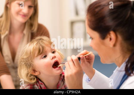 Petite fille ayant l'examen de la gorge par le pédiatre à l'aide de stylo lumière Banque D'Images