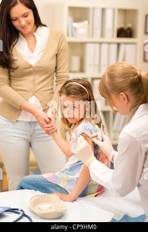 Peu de fille obtenant la vaccination de pédiatre à office Banque D'Images