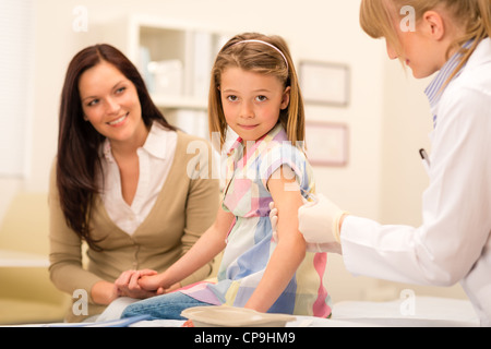 Peu de fille obtenant la vaccination de pédiatre à office Banque D'Images