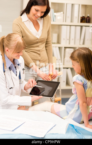 Pédiatre point à tablet x-ray girl jambe cassée medical office Banque D'Images