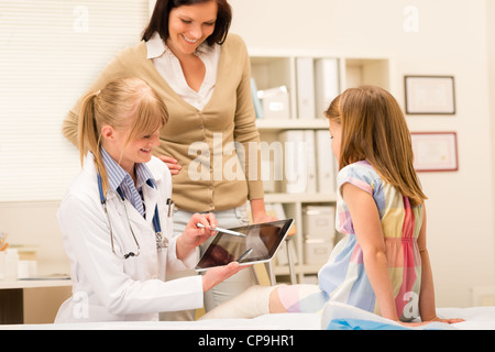 Pédiatre point à tablet x-ray girl jambe cassée medical office Banque D'Images