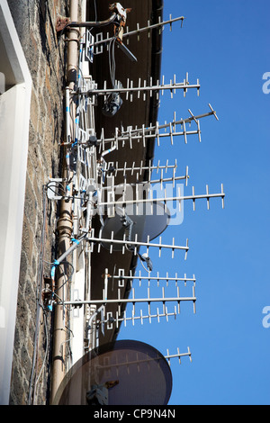 Grande quantité d'antennes tv et les récepteurs satellites sur un mur d'un immeuble en Ecosse UK Banque D'Images