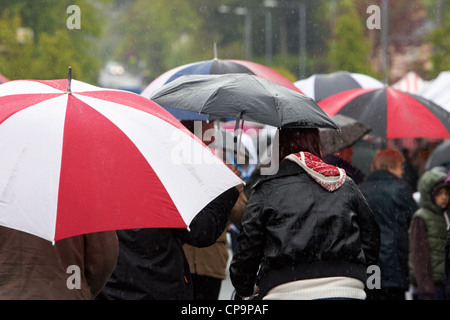 Gens portant des parapluies en ville à pied sous la pluie d'Irlande Royaume-Uni Banque D'Images