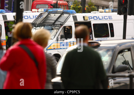 Cars de police garée près de Trafalgar Square, avec des personnes et d'un taxi dans l'avant-plan Banque D'Images