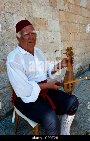 Musicien de rue en costumes médiévaux historiques jouant un instrument à cordes, Old Town, Dubrovnik. La Croatie. Banque D'Images