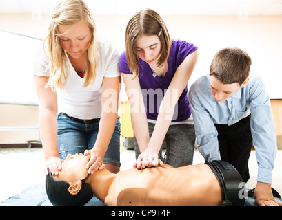 Les élèves pratiquant en secourisme RCR sur un mannequin. Banque D'Images