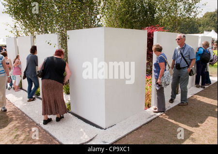 Les gens en échange de l'affichage et le 'jardin' Kaléidoscope dans l'écart au mur (panneaux blancs) - RHS Flower Show, Tatton Park, Cheshire, Angleterre. Banque D'Images