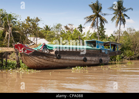 Un bateau typique à un amarrage riverside, Cai Be, Delta du Mekong, Vietnam Banque D'Images