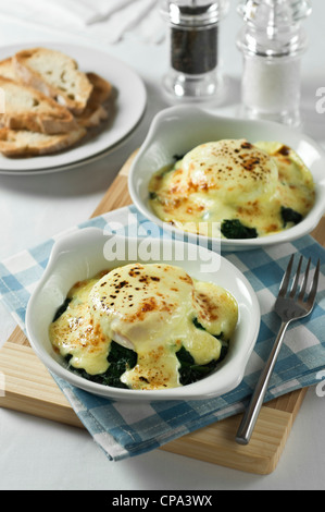 Oeufs florentine. Les oeufs pochés sur les épinards avec sauce au fromage. Banque D'Images