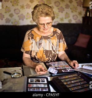 Monsieur femme âgée avec collection de timbres-poste Banque D'Images