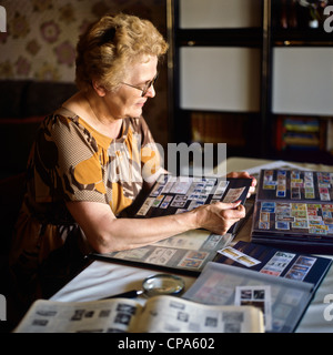 Monsieur femme âgée avec collection de timbres-poste Banque D'Images