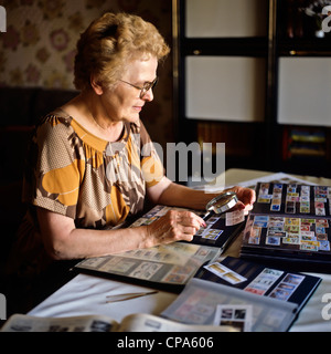 Monsieur femme âgée avec collection de timbres-poste Banque D'Images