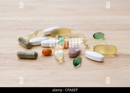 Sélection de suppléments de vitamine (oméga 3, Co-enzyme Q10, menthe, chondroïtine, ginkgo et ginseng) sur planche à découper Banque D'Images