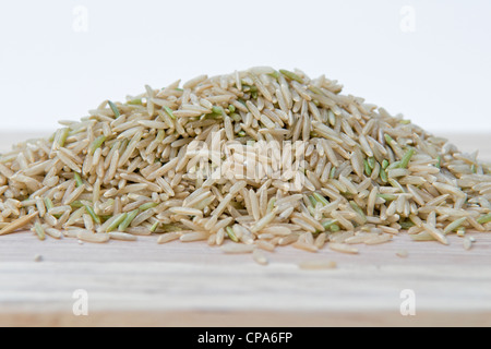 Riz basmati brun non cuit sur planche à découper sur un fond blanc. Banque D'Images