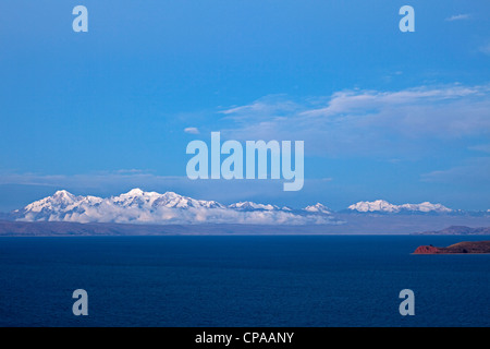 L'île de la Lune dans le lac Titicaca en Bolivie au coucher du soleil avec les montagnes des Andes enneigée derrière, vues du Sun Island. Banque D'Images