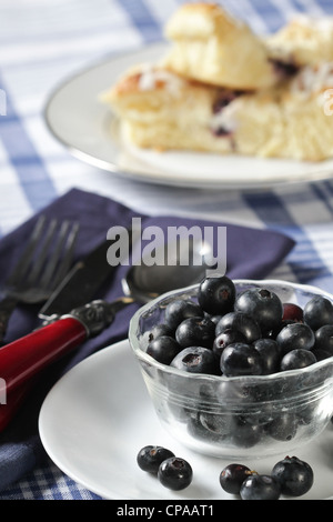 Bol en verre de bleuets frais pain gâteau aux bleuets avec en arrière-plan, avec l'argenterie sur une serviette bleue. Banque D'Images