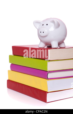 Tirelire sur une pile de livres colorés (isolé sur blanc) Banque D'Images