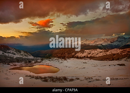 USA, Colorado, Cottonwood Pass. Coucher de soleil sur tarn alpin entouré de neige fraîche Banque D'Images