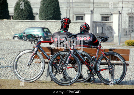 Deux cyclistes ayant une pause sur un banc Banque D'Images