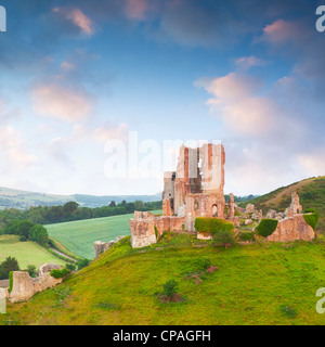 Château de Corfe sur sa colline au dessus de la belle campagne du Dorset, au lever du soleil. Banque D'Images