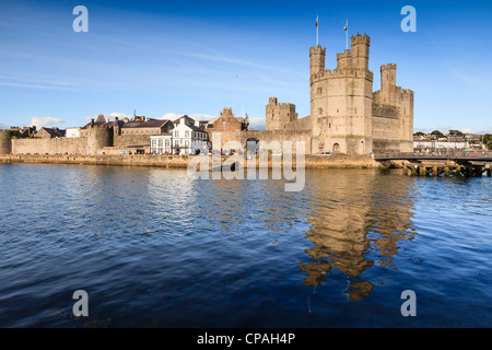 Un soir d'été au château de Caernarfon, Gwynedd, au nord du Pays de Galles. Le château se reflète dans la rivière Banque D'Images