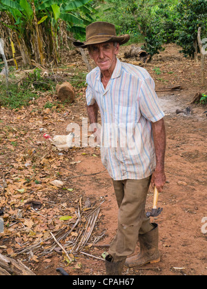 Un homme âgé de 70 à 80 ans cultivateur de tabac cubain travaille avec ses outils par son hangar à Viñales, Cuba dans l'ouest de Cuba. Banque D'Images