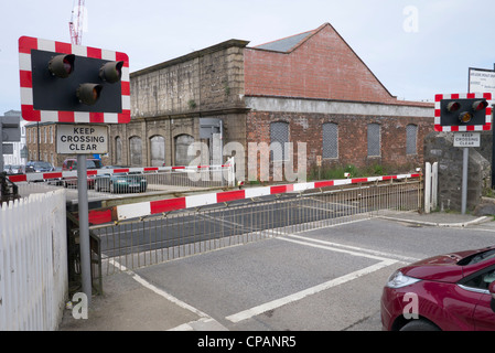 La barrière de passage à niveau fermé la porte avant qu'un train passe à travers à Redruth, UK. Banque D'Images