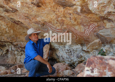 Phillott Charles, propriétaire-exploitant de station Carisbrooke en outback Queensland, explique les peuples Rainbox peinture serpent Banque D'Images