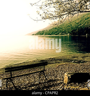 Banc de parc au bord du Lac Majeur d'automne le matin Banque D'Images