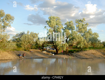 Une famille à la pêche à bord de la rivière Thompson près de Longreach dans outback Queensland, Australie Banque D'Images