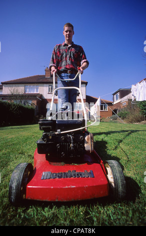 Man mowing lawn garden sur summer day uk Banque D'Images