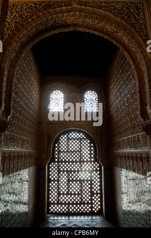 Reliefs richement décoré de fenêtres cintrées surround dans les Palais Nasrides de l'Alhambra à Grenade, Espagne. Banque D'Images