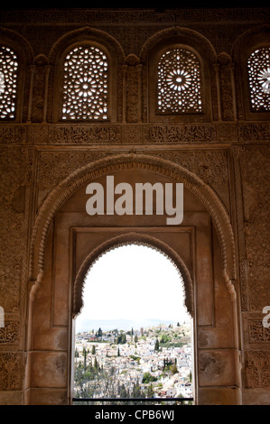 Reliefs richement décoré de fenêtres cintrées surround dans les Palais Nasrides de l'Alhambra à Grenade, Espagne. Banque D'Images