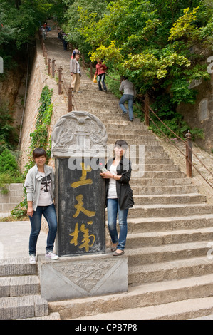 2 filles Chinois posent pour la caméra et montrant les étapes escarpées menant le mont Kongtong près de Pingliang ville de Chine. Banque D'Images
