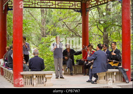 Un groupe chinois/bande de musiciens jouent de la musique traditionnelle chinoise d'erhu (violon chinois - instrument principal) tôt le matin dans un parc Banque D'Images