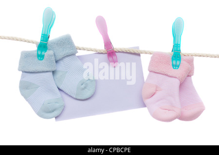 Chaussettes bébé bleu et rose avec enveloppe vide accroché sur corde Banque D'Images