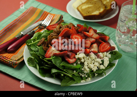 Déjeuner d'une salade d'épinards avec plaque de pacanes, les fraises et le fromage bleu, servi avec de la cannelle et de l'eau glace pain streusel. Banque D'Images