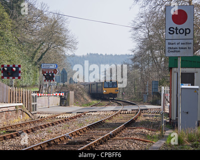 L'approche d'un train à un passage à niveau sans pilote à l'extérieur de la station dans le Devon Eggesford sur la ligne entre Exeter et Bristol UK Banque D'Images