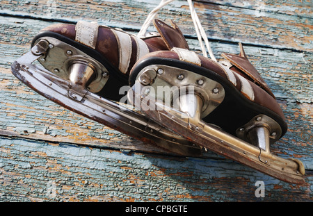 Vintage paire de patins à glace mens accrochée à un mur en bois Banque D'Images