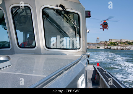 Un United States Coast Guard hélicoptère Dauphin HH-65C s'approche d'un navire de la Garde côtière auxiliaire. Banque D'Images