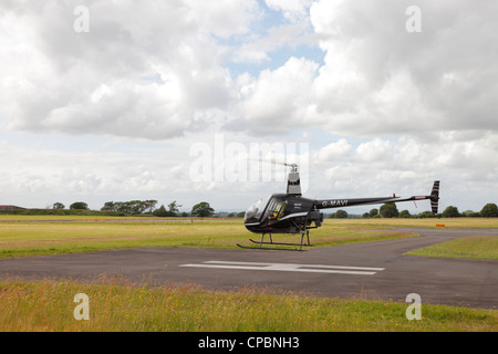 Robinson R22 Beta d'hélicoptères utilitaires légers à l'atterrissage à l'aéroport de Carlisle, Cumbria UK Banque D'Images