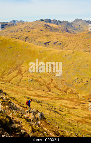 Walker en ordre décroissant Wetherlam Edge sur Wetherlam Lake District avec Crinkle Crags et Bowfell sur l'horizon Banque D'Images