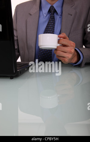 Businessman avec un café et un ordinateur portable Banque D'Images