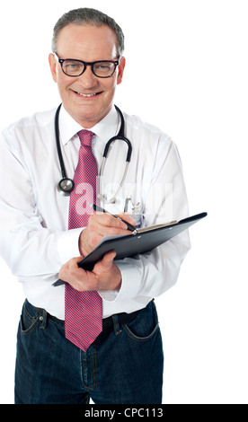 Happy smiling mûri médecin writing on clipboard isolés contre fond blanc Banque D'Images