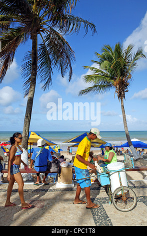 Le Brésil natal personnes à pied et on vend de la crème glacée et des T-shirts dans le trottoir de la plage jour ensoleillé, ciel bleu Banque D'Images