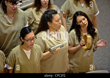 Un chœur de femmes détenues au Santa Ana, CA chante à la prison de la ville de graduation d'une prison programme éducatif. Banque D'Images