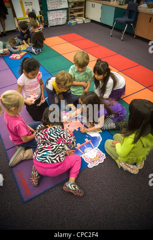 Sur un sol de la classe, un groupe d'enfants de maternelle collaborer pour assembler un puzzle à San Clemente, CA. Banque D'Images