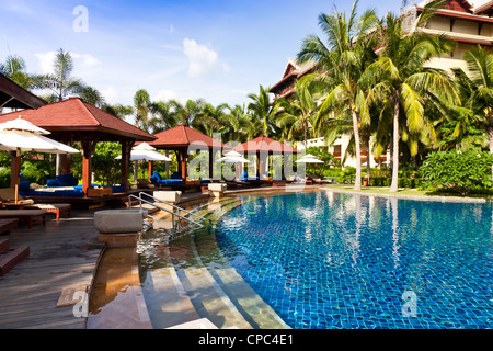 Piscine avec parasol et lit de massage au bord de la piscine. Banque D'Images